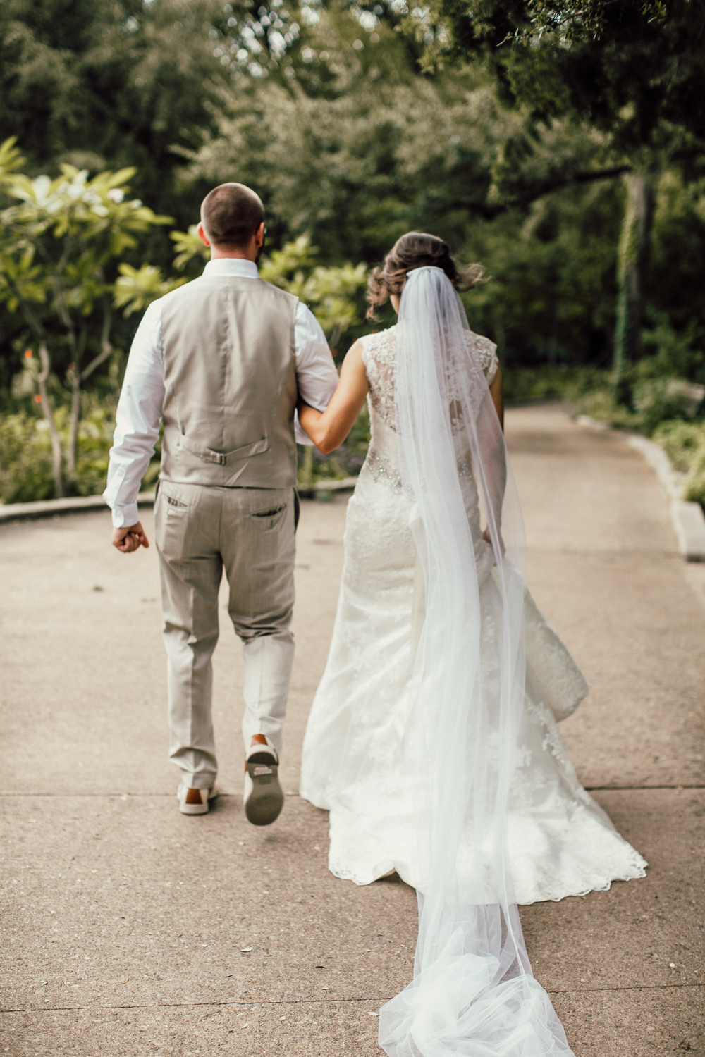Wedding couple walking through Zilker Botanical Gardens after exchanging vows in Austin, Texas.