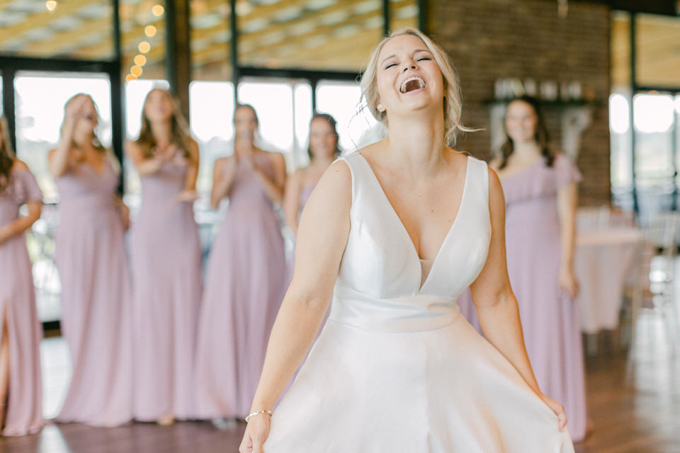 A bride laughing with her bridesmaids during their first look is am important moment.