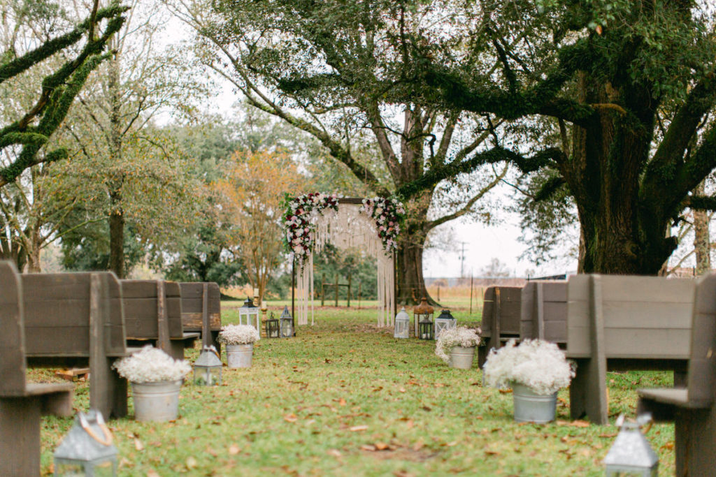 An outdoor wedding under the canopy of trees.